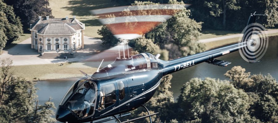 Helicopter flying over scenic estate, showcasing Helipaddy's luxury travel experience.