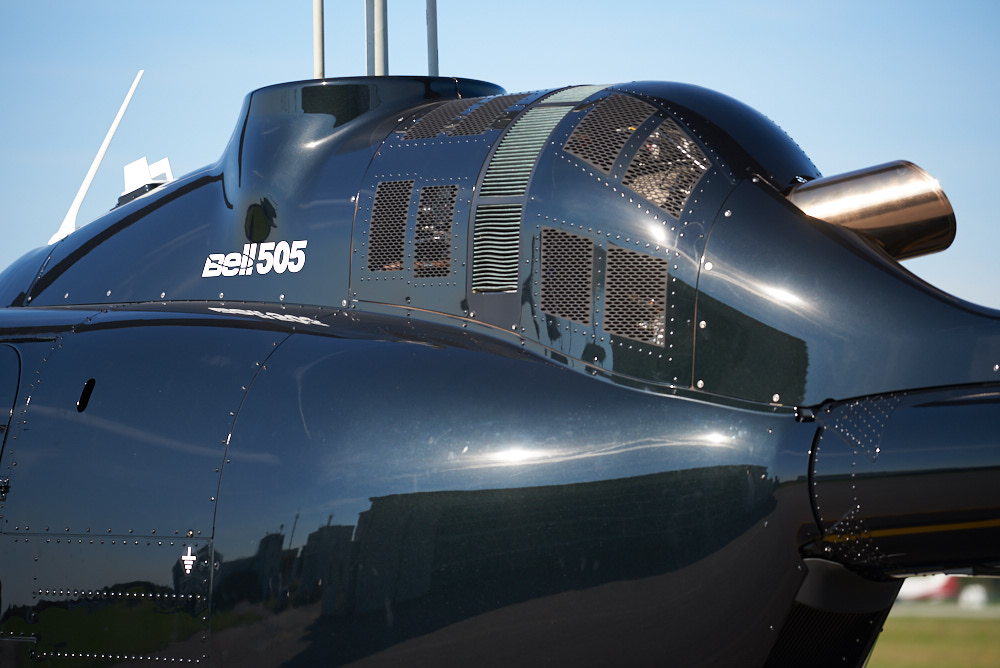 Close-up of a Bell 505 helicopter under clear skies, highlighting Helipaddy's expertise in aviation landings.