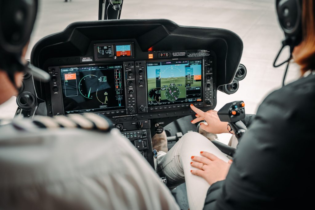 Helicopter cockpit with pilots using advanced controls, showcasing Helipaddy navigation system in flight.