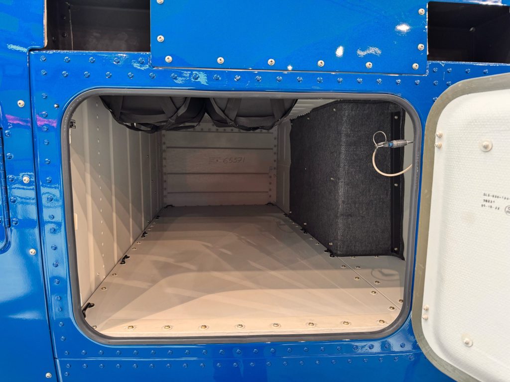 Open helicopter cargo compartment, showcasing storage space, related to Helipaddy aviation services.